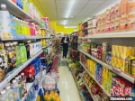 图为郭平安去超市购买食物。　高康迪 摄 - 甘肃新闻