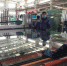 图为白银市白银区一家钢化玻璃厂车间内切割生产线工作。　张婧 摄 - 甘肃新闻