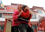 图为藏族孩童在搬迁后的新家玩耍。(资料图) 杨丽君 摄 - 甘肃新闻