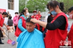 图为金川区街道社区志愿者正在进行每月一次义务剪发。　高康迪 摄 - 甘肃新闻