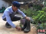 图为元古堆村民李有录翻出“压箱底”的旧雨靴，鞋底已弯曲变形。　张婧 摄 - 甘肃新闻