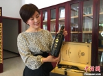 图为王玉兰向记者展示企业研发的党参葡萄酒。　张婧 摄 - 甘肃新闻