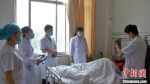 天津医生李汶泽(右二)在病房为患者指导诊断病情，同时为年轻医生传授相关经验。　李文 摄 - 甘肃新闻