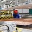 兰州高新区的甘肃元能新型材料科技有限公司生产车间，工人正在控制机床生产复合墙板。(资料图) 高展 摄 - 甘肃新闻