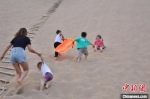图为游客带着孩童在金塔县景区内游玩。(资料图) 卢玉 摄 - 甘肃新闻