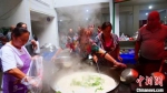 图为文县碧口镇妇女在安置点烹饪“大锅饭”，并发放给民众。　王小勇 摄 - 甘肃新闻