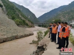 专家组在G212线宕昌县境内查看滑坡阻塞河道、冲毁路基情况。　交通运输部供图 - 甘肃新闻