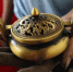 定西市铜铝翻砂铸造非物质文化遗产传承人蒋胜平正展示他铸造的铜器。　于晶 摄 - 甘肃新闻