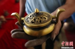 定西市铜铝翻砂铸造非物质文化遗产传承人蒋胜平正展示他铸造的铜器。　于晶 摄 - 甘肃新闻