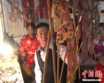 刘国天(左二)在表演现场挂皮影。(资料图)通渭县宣传部供图 - 甘肃新闻