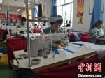 图为工人们缝制衣服。　冯志军 摄 - 甘肃新闻