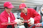 刘玲玲(右)正和工友检修器械。(资料图) 受访者供图 摄 - 甘肃新闻