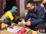 苹果产业是镇原县的富民脱贫产业。图为王峰与农户查看苹果收成。　侯志雄 摄 - 甘肃新闻