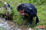 图为2016年9月，民警在巡山时喝山间泉水。(资料图) 李炳华 摄 - 甘肃新闻