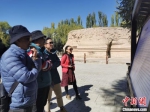 图为游客在浏览关于萨班灵骨塔遗址的讲解资料。(资料图) 闫姣 摄 - 甘肃新闻