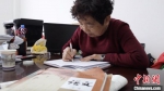 图为58岁的闫桂珍伏案做笔记。今年，是她从东北来到嘉峪关市的第35年。　高莹 摄 - 甘肃新闻
