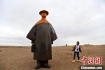 　2020年9月5日，甘肃民勤县沙漠里的雕塑作品《丝路旅人》吸引民众。(资料图) 杨艳敏 摄 - 甘肃新闻