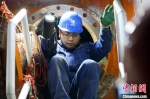 图为刘家峡水电厂检修人员艰难钻出机组蜗壳门。(资料图) 高展 摄 - 甘肃新闻