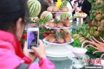 民众利用手机给展示台上优质马铃薯拍照。(资料图) 张婧 摄 - 甘肃新闻