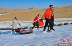 图为游客和市民在鸣沙山下享受大漠冰雪带来的欢乐。　王斌银 摄 - 甘肃新闻
