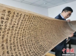 2020年9月底，读者集团敦煌文艺出版社社长展示《敦煌法藏文献》的复制品。(资料图) 闫姣 摄 - 甘肃新闻