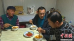 图为孙崇吉(中)与同事在驻守地吃饭。　周建辉 摄 - 甘肃新闻