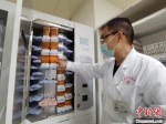 图为在住院部药房工作8年时间的主管药剂师杨天才向记者展示全自动片剂摆药机。　张婧 摄 - 甘肃新闻