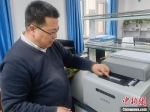 车团结向记者介绍ASA-9600实时荧光定量PCR仪器工作原理。　高康迪 摄 - 甘肃新闻