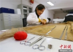 4月下旬，赵喜梅正在修复南北朝时期纺织品文物。　高展 摄 - 甘肃新闻