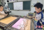 图为七里河小学学生创作沙画。　高展 摄 - 甘肃新闻