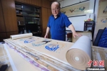 图为范兴儒展示他最珍视的《八十七飞天卷》，耗时5年所作，画卷长50米，包含87身代表飞天。　高展 摄 - 甘肃新闻