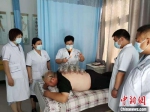图为冯世霞(左三)正在为患者进行拔罐治疗。(资料图) 受访者供图 - 甘肃新闻