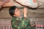 图为2005年杜建君在洞窟内工作。(资料照片) 敦煌研究院供图 - 甘肃新闻