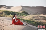 图为玛尔健坐在甘肃肃南县的沙漠一隅，回忆过去，感受家乡多年来的变化。(资料图) 玛尔健供图 - 甘肃新闻