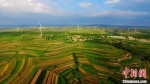 图为在甘肃定西市，远处的风力发电机组和近处的梯田自成一景。(资料图) 王金生 摄 - 甘肃新闻