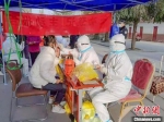 图为罗晓媛(中间)正在为居民做核酸检测。　甘肃省张掖市山丹县消防救援大队供图 - 甘肃新闻