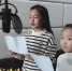 兰州市少年宫的张子馨(右)和孔一涵(左)小朋友用童真的歌声演唱《送你一朵小红花》致敬全体抗疫工作者。　郑云洁 摄 - 甘肃新闻