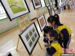 图为野生动物主题的作品吸引孩子们驻足观看。　徐雪 摄 - 甘肃新闻
