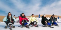图为新年伊始，游客在敦煌沙漠露营基地享受滑雪的乐趣。　张晓亮 摄 - 甘肃新闻