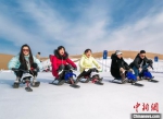 图为新年伊始，游客在敦煌沙漠露营基地享受滑雪的乐趣。　张晓亮 摄 - 甘肃新闻
