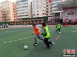 图为课间时分，操场上奔跑的足球少年。　杨娜 摄 - 甘肃新闻