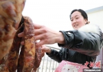杨太明丈夫从老家带来了香肠、腊肉，她正在翻晒。　魏建军 摄 - 甘肃新闻