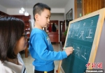 图为小学生芮明亮在家给家长讲解汉字笔画。　艾庆龙 摄 - 甘肃新闻