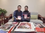 图为陈晓斌(左)向中新网记者介绍他所收藏的舞剧《丝路花雨》相关珍贵资料情况。　崔琳 摄 - 甘肃新闻