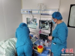 图为医护人员在造血干细胞移植仓内护理患者。　王立 摄 - 甘肃新闻