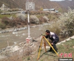 图为常福昌测量河流水面高程。(资料图) 甘肃省水利厅供图 - 甘肃新闻